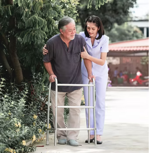 Caregiver warmly supporting an older gentleman outdoors