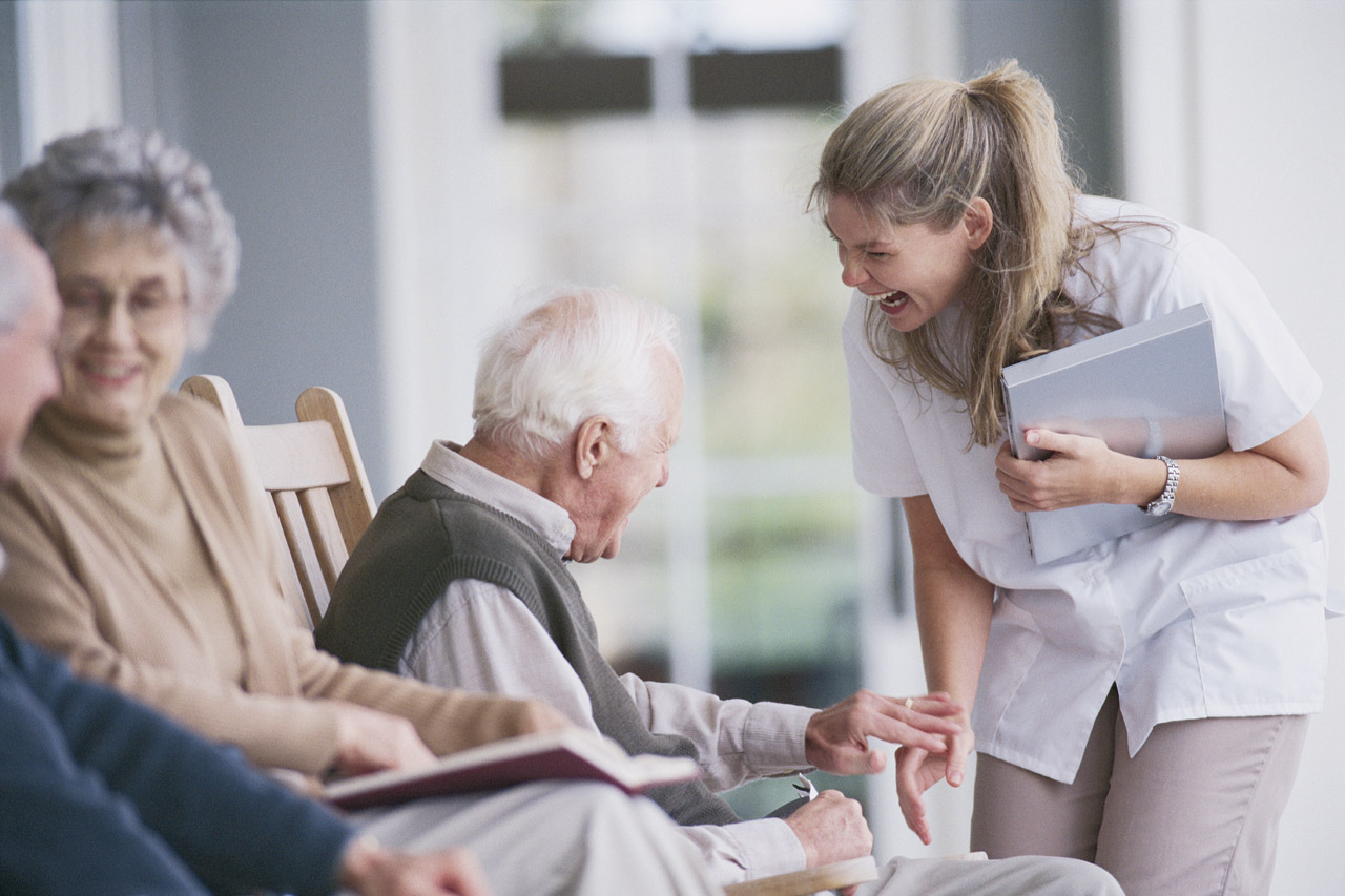 Caregiver warmly supporting an older gentleman outdoors